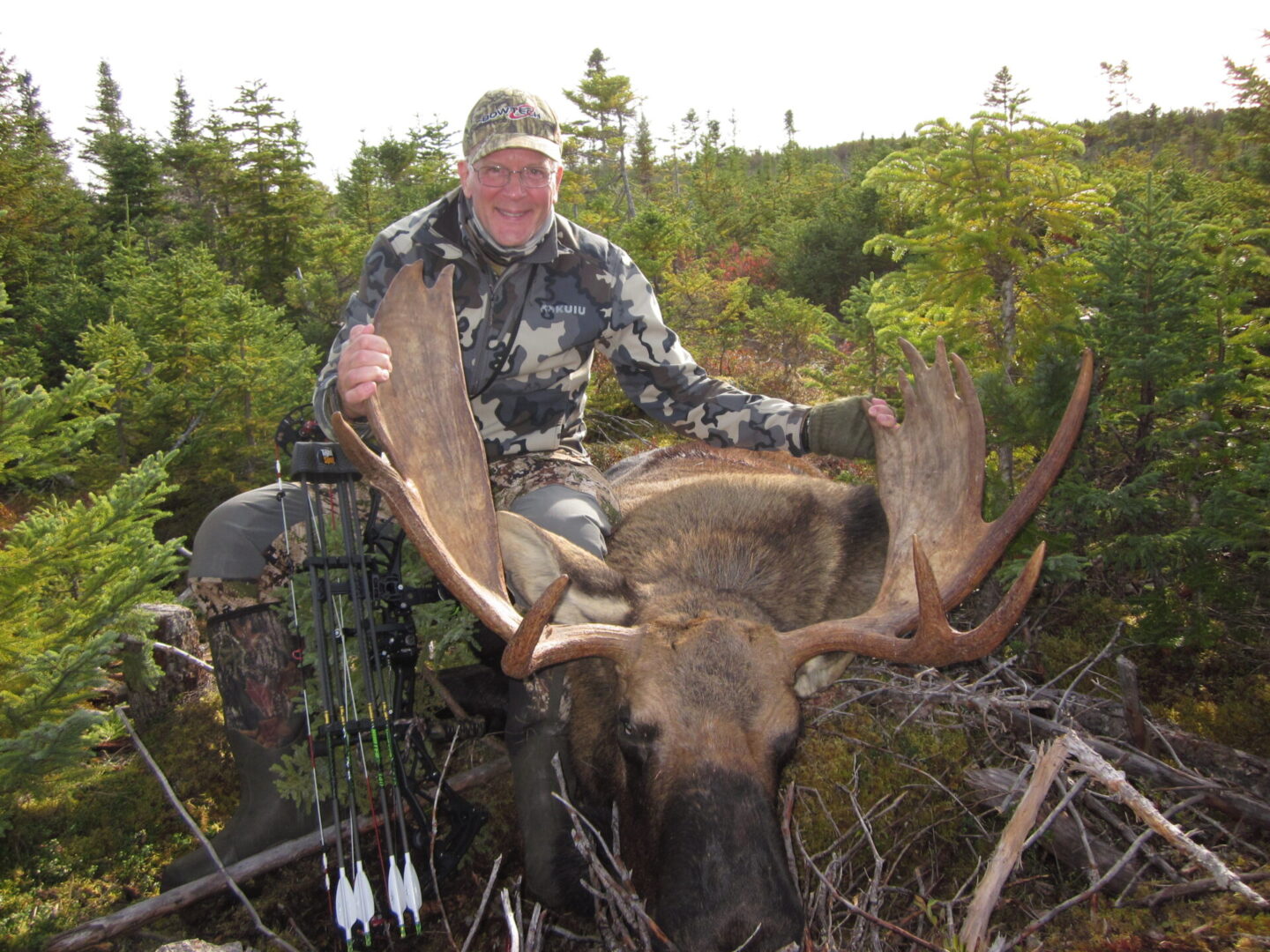 A man posing with a dead moose