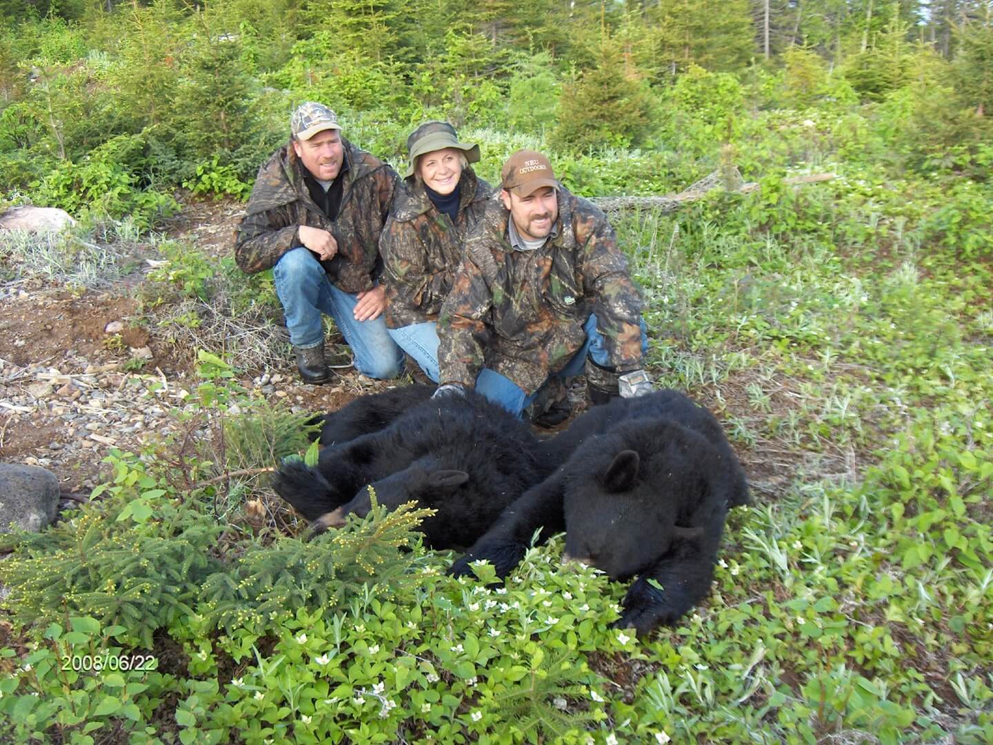 Three hunters in a clearing with their hunted bears